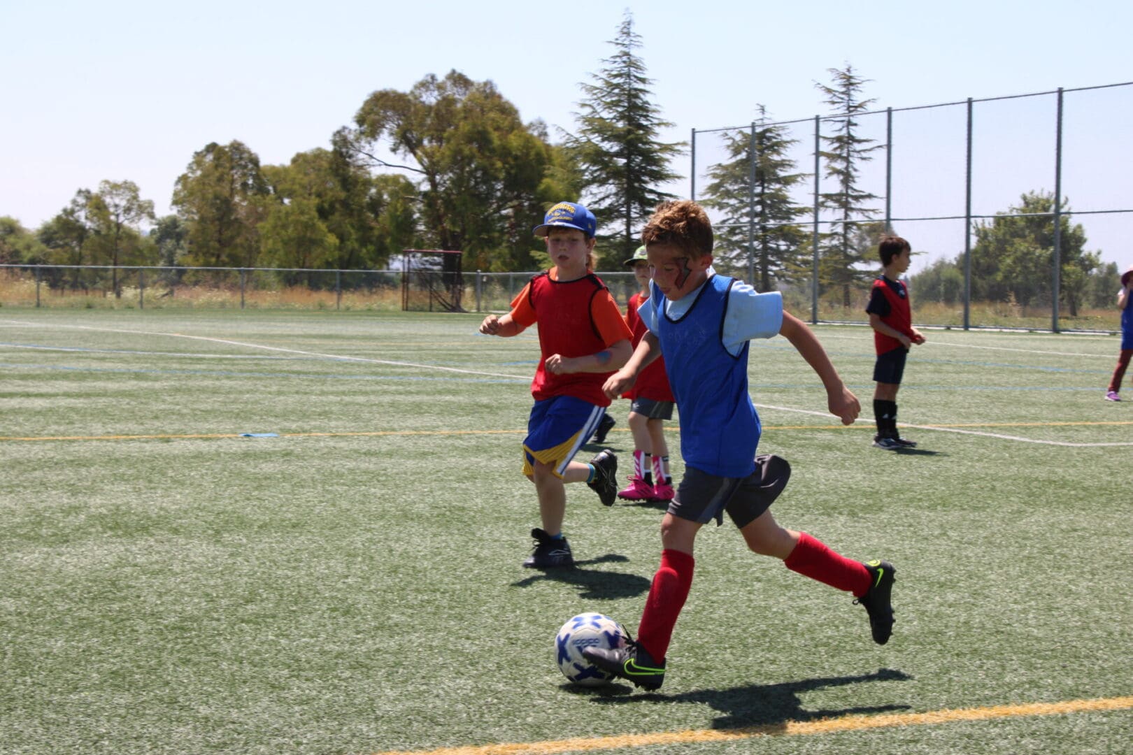 A group of young people playing soccer on a field.