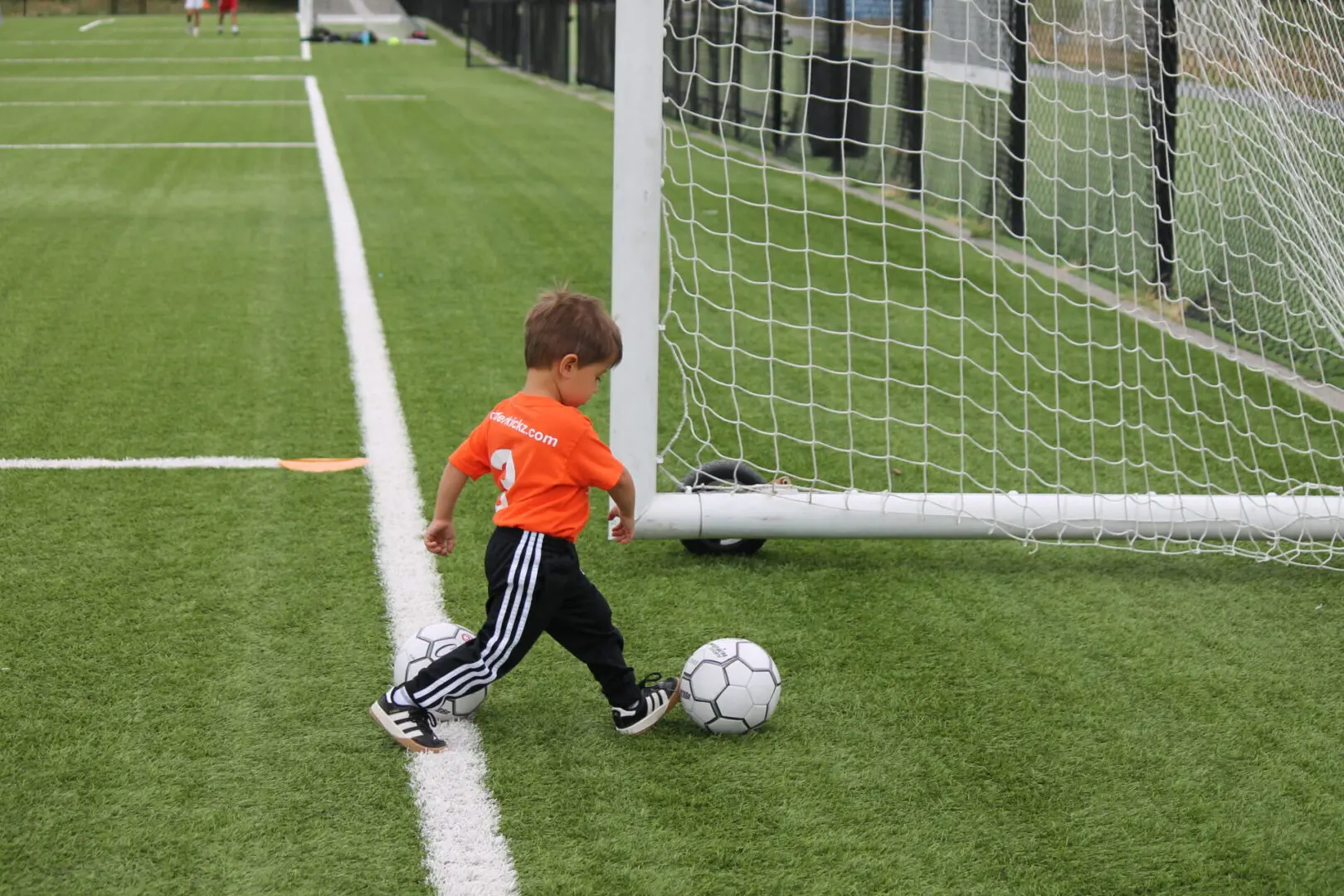 A young boy kicking around a soccer ball.