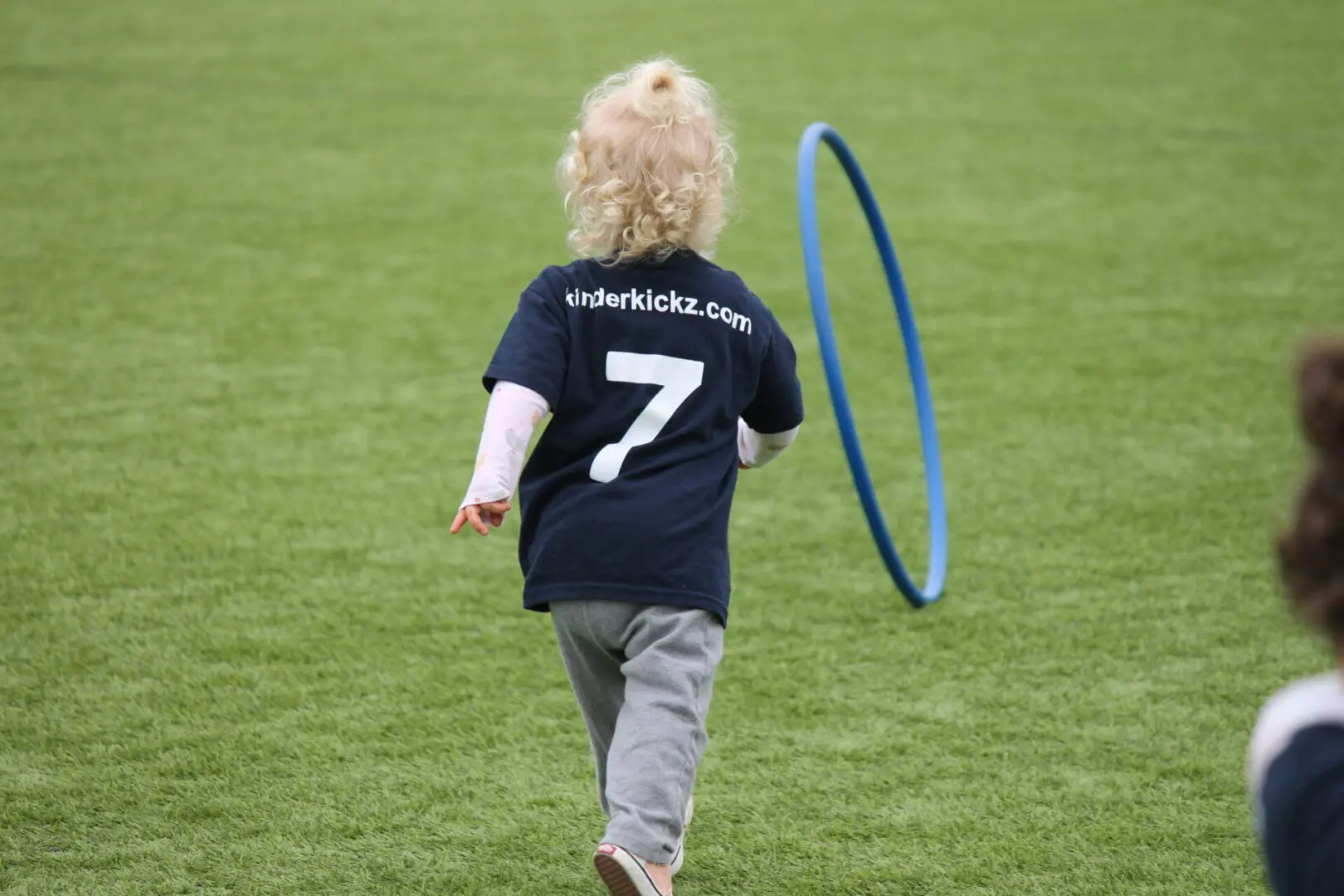 A child is playing with a frisbee on the grass.